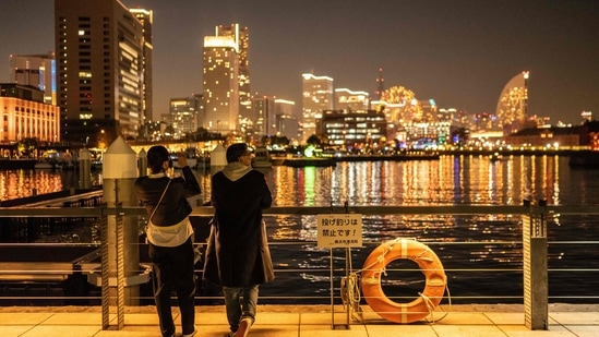 A couple visit a park in Yokohama. New Year 2023 travel alert: Japan's Yokohama introduces Ramen Museum (Photo by Yuichi YAMAZAKI / AFP)