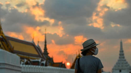 Thailand Traffic Campaign: A tourist wears a face mask to prevent spread of the coronavirus disease (Covid-19) during sunset near the Grand Palace in Bangkok, Thailand.(Reuters)