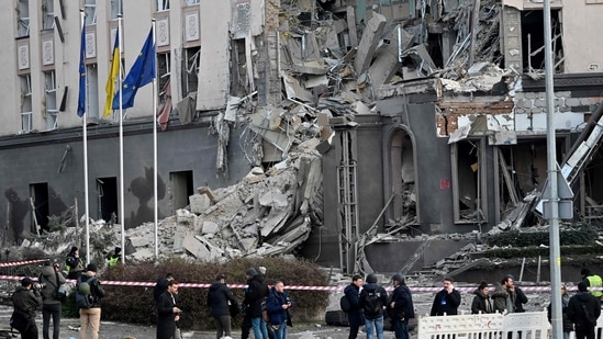 People gather at the bottom of a hotel, which has been partially destroyed by a Russian strike in the center of the Ukrainian capital, Kyiv on December 31.(AFP)