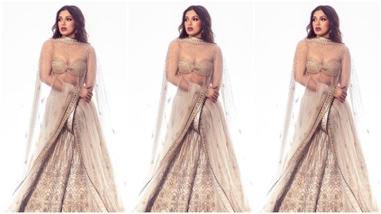 While the golden-coloured blouse features spaghetti straps, a deep sweetheart neckline, an infinity hem design and a fitted bust, the off-white lehenga has intricate embroidery work, sequin adornments, and an A-line layered ghera. She completed the outfit with a see-through zari dupatta - adorned with a gota patti border and embellishments - draped on the shoulders. (Instagram)