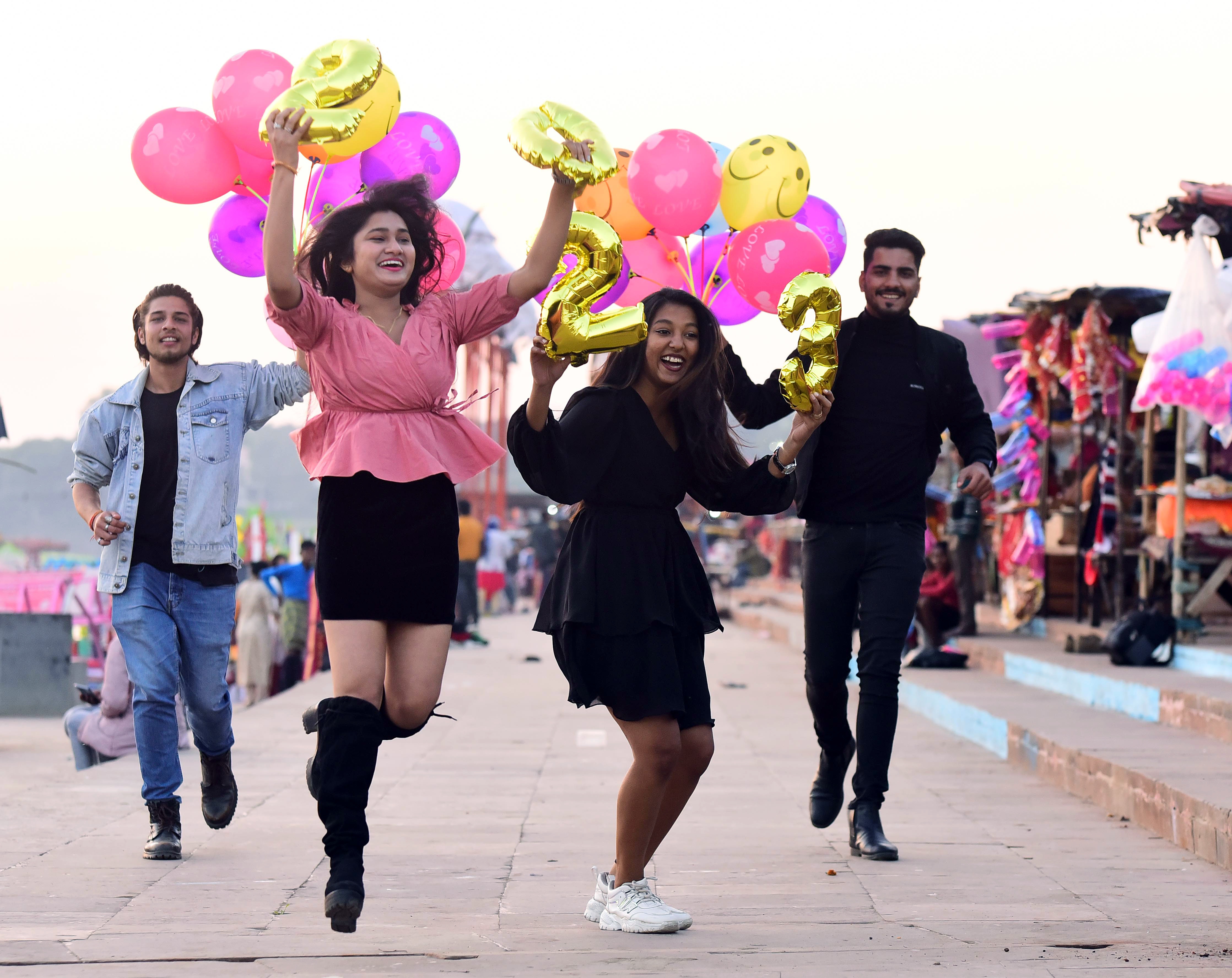 Youngsters holding balloons pose for a picture during the New Year 2023 celebrations. (ANI)