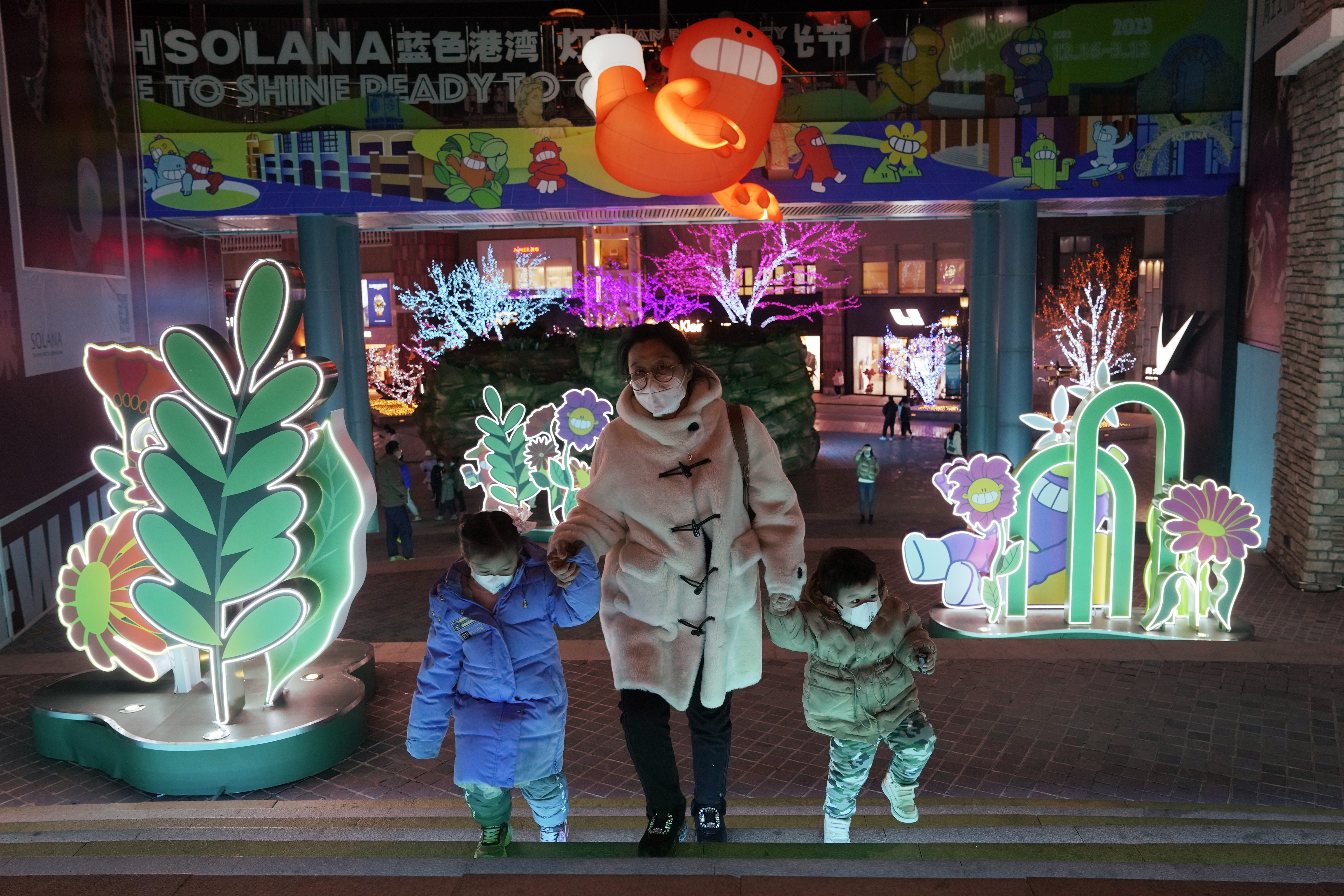Visitors wear masks as they visit light decorations at a mall in Beijing. (AP)