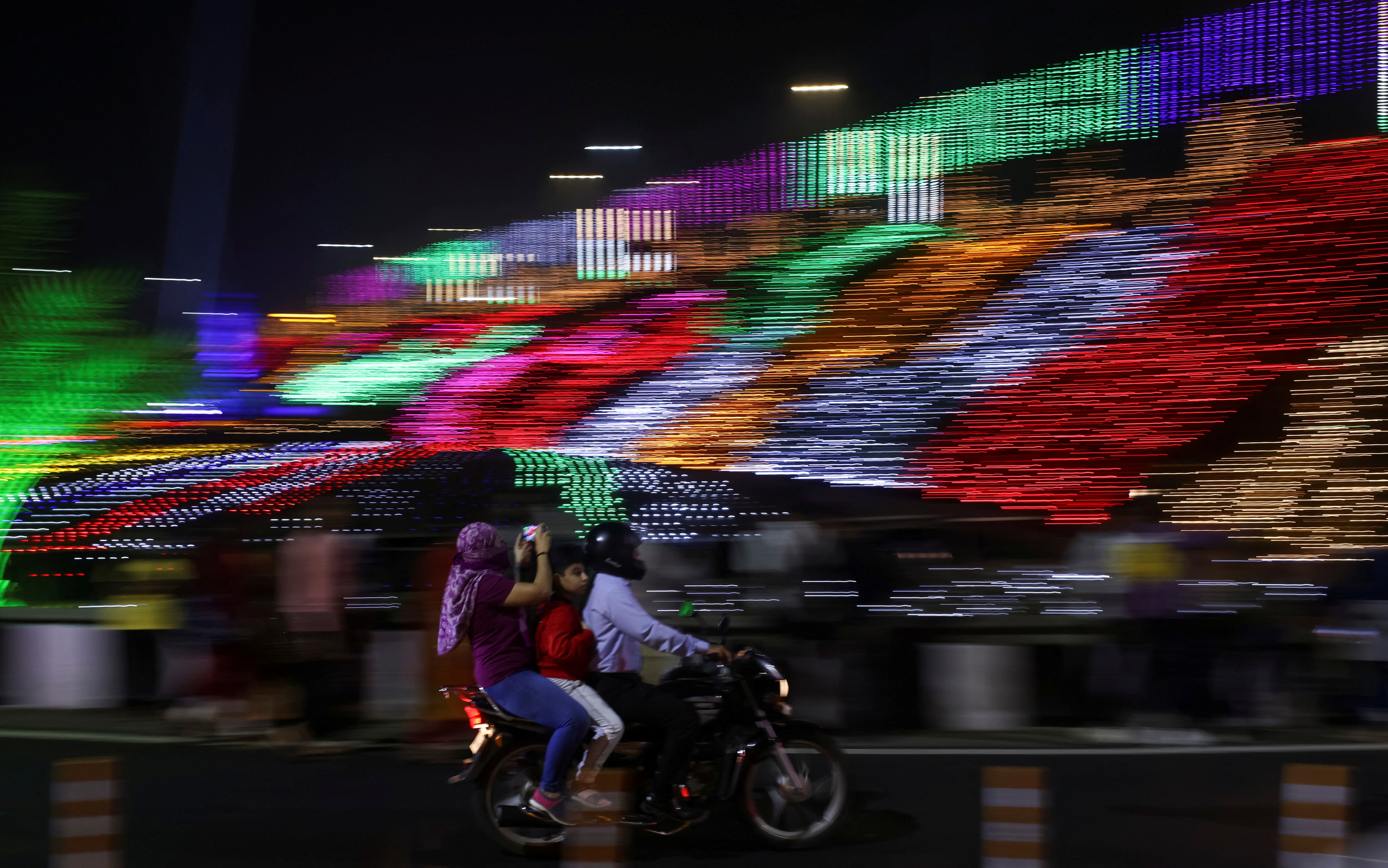 A man rides a motorcycle past decorations ahead of New Year's celebrations on a street in Mumbai. (Reuters)