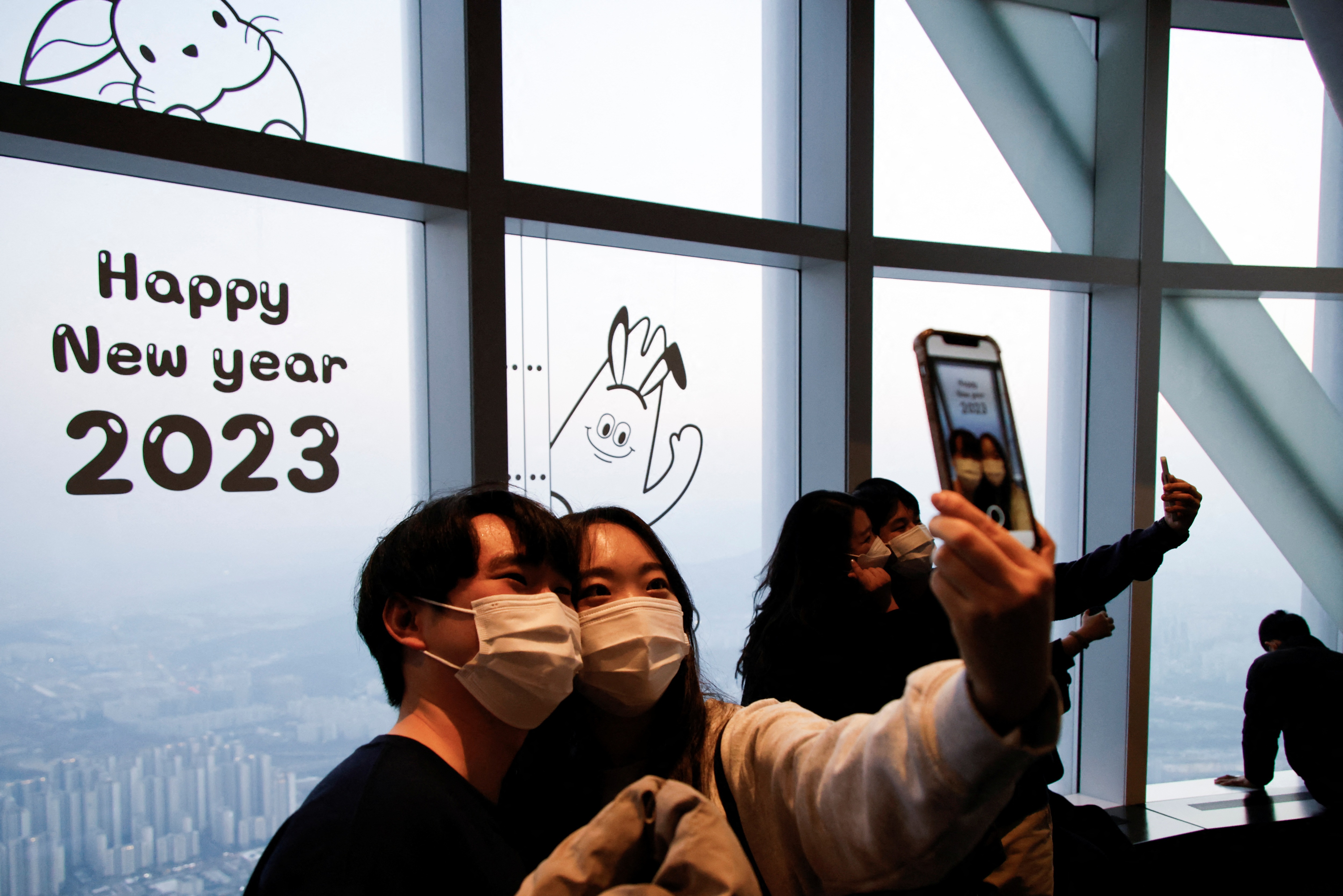 A couple takes a selfie with the setting sun on New Year's Eve at the Seoul Sky Observatory in Seoul, South Korea. (Reuters)