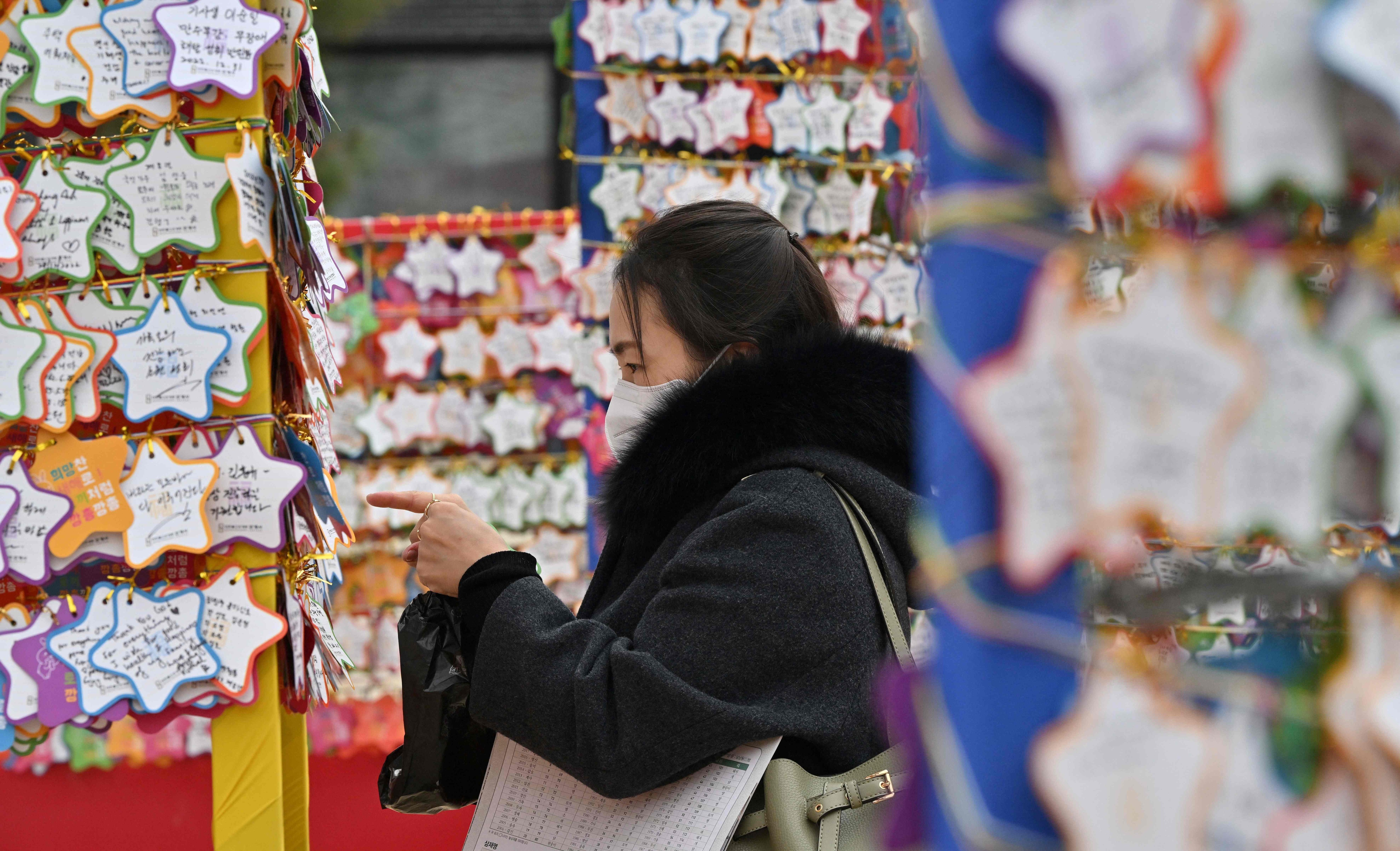 A Buddhist follower attaches name cards with wishes during celebrations for the New Year at Jogye temple in central Seoul. (AFP)