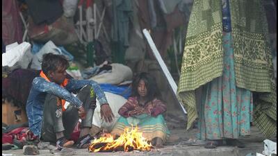 People warm themselves near a fire during a cold and foggy morning in New Delhi. (PTI) People warm themselves near a fire during a cold and foggy morning in New Delhi. (PTI)