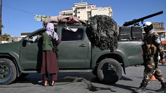 Kabul Military Airport Blast: Taliban fighters stand guard as they block a road near Kabul.(AFP)