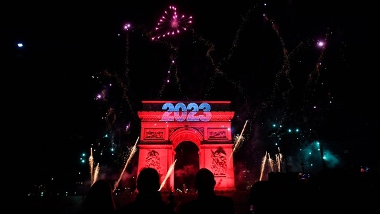 Fireworks explode next to the Arc de Triomphe, at the Avenue des Champs-Elysees during New Year celebrations in Paris, early on January 1, 2023. (AFP)