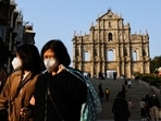 People wearing face masks walk in front of the ruins of Saint Paul's during the coronavirus disease (Covid-19) pandemic in Macau, China. Macau eases Covid-19 travel rules but tourism, casinos yet to rebound 