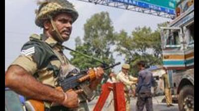 A BSF jawan stands guard as J&K Police personnel check vehicles on the Jammu-Srinagar highway. (PTI File Photo)