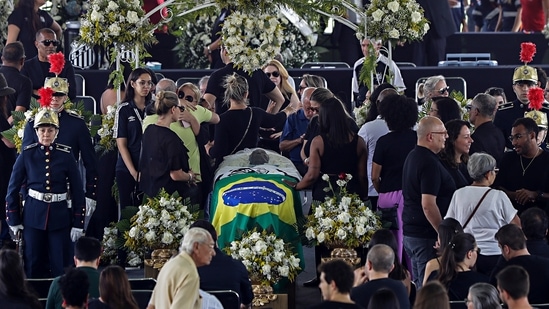 People pay their last respects to the late Brazilian soccer great Pele whose lies in state at Vila Belmiro stadium in Santos, Brazil.(AP)