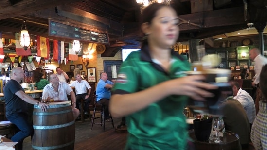 Dubai Alcohol Tax Rule: A waitress serves customers beer at a restaurant in Dubai.(AP)