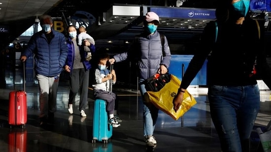 Covid In China: Travellers walk with their luggage at Beijing Capital International Airport.