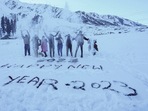 Tourists pose for photographs near a message ' Happy New Year 2023' carved on snow at a ski resort, in Gulmarg, Jammu and Kashmir, Saturday, Tourists pose for photographs near a message ' Happy New Year 2023' carved on snow at a ski resort, in Gulmarg, Jammu and Kashmir, Saturday,