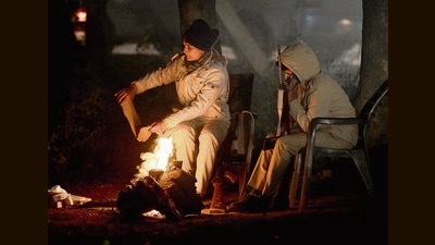 Cops on night duty light up a bonfire to stay warm amid dipping temperatures, on Nayagaon-Chandigarh border on Tuesday. (Keshav Singh/HT)