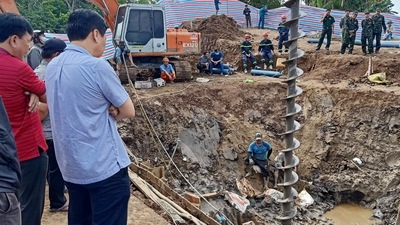 Vietnam: Rescuers look down into the site of where a 10-year-old boy is thought to be trapped. (AFP) Vietnam: Rescuers look down into the site of where a 10-year-old boy is thought to be trapped. (AFP)