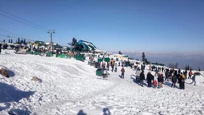 Tourists enjoy at the famous Gulmarg ski resort, in Baramulla on Tuesday. (ANI)