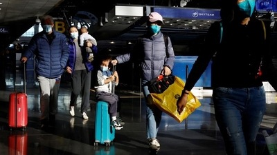 Travellers walk with their luggage at Beijing Capital International Airport. (Reuters)