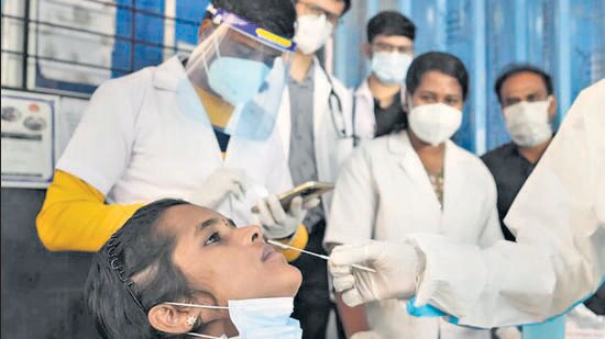 A medic collects a sample for the Covid-19 test at a public health centre, in Bengaluru on Tuesday. (PTI)