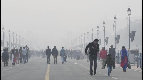People take a stroll at Kartavya Path amid dense fog on a cold winter day in New Delhi. (ANI Photo)