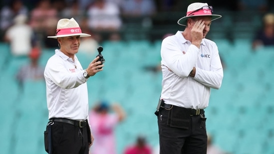 Umpires Chris Gaffaney (L) and Paul Reiffel check a light meter reading during a delay due to bad light on Day 1 of the 3rd Test between Australia and South Africa(AFP)