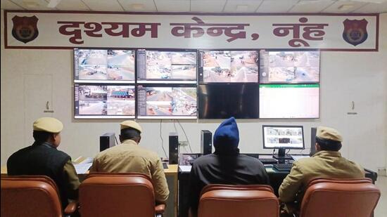 Police officers monitor CCTV footage at the Drishyam Kendra in Nuh. (HT Photo)
