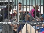 Recently arrived migrants wait in a garage area of the US Customs and Border Protection.(AP) Recently arrived migrants wait in a garage area of the US Customs and Border Protection.(AP)