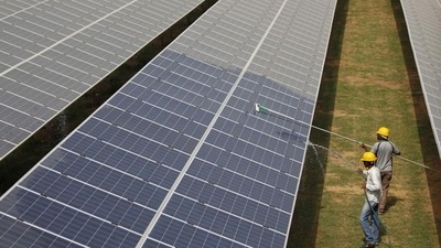 Workers clean photovoltaic panels inside a solar power plant in Gujarat, India. Workers clean photovoltaic panels inside a solar power plant in Gujarat, India.