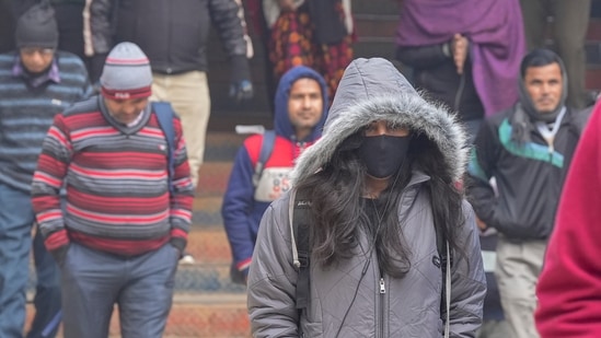 Commuters exit the Shivaji Bridge station on a cold and foggy winter morning, in New Delhi, on January 5. Delhi airport said low visibility procedures and measures for making landing easier when visibility dips below 800 metres were kicked in. “All flight operations are presently normal. Passengers are requested to contact the airline concerned for updated flight information,” the airport tweeted, according to Hindustan Times.(Vijay Verma / PTI)