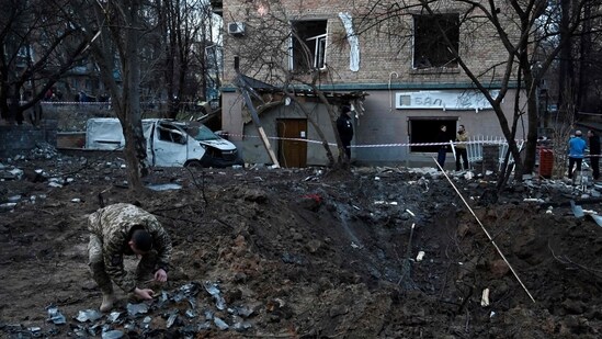 Russia-Ukraine War: A serviceman collects fragments of missile in a crater left by a Russian strike in Kyiv.(AFP)