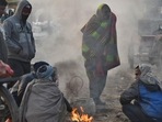 People warm themselves around a bonfire on a cold winter morning at Ghazipur market in New Delhi. People warm themselves around a bonfire on a cold winter morning at Ghazipur market in New Delhi.