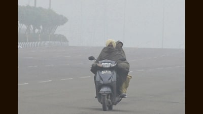 Commuters on their way on a foggy Friday morning in Chandigarh. (Ravi Kumar/HT)