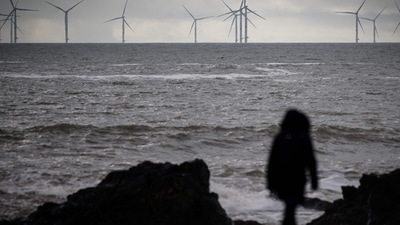France Weather: A woman walks down a beach in Saint-Nazaire in France. (AFP) France Weather: A woman walks down a beach in Saint-Nazaire in France. (AFP)
