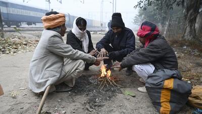 People around a bonfire at Daulatabad village near Laxman Vihar in Gurugram on Thursday morning. (Parveen Kumar/HT Photo)