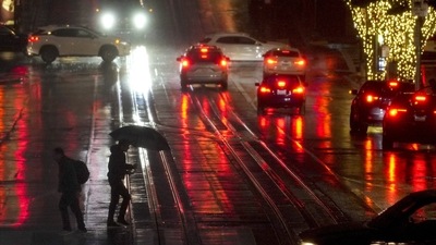 California Storm: People walk across California Street in San Francisco. (AP)