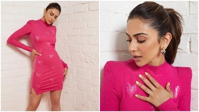 Rakul's dress features a turtle neckline, padded shoulders, full-length sleeves, a mini-length hem, slits on both sides, glitter stripes, embellished heart-shaped adornments, and a figure-hugging silhouette. She styled it with several statement rings, white pointed stilettos, and silver gold earrings. (Instagram) Rakul's dress features a turtle neckline, padded shoulders, full-length sleeves, a mini-length hem, slits on both sides, glitter stripes, embellished heart-shaped adornments, and a figure-hugging silhouette. She styled it with several statement rings, white pointed stilettos, and silver gold earrings. (Instagram)