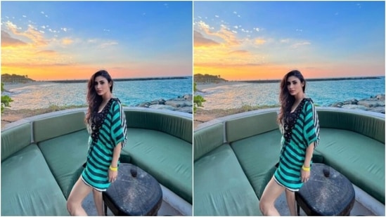 Mouni posed for a picture in a deck of sorts with the amazing view of lapping blue waters and the setting sun in the backdrop.&nbsp;(Instagram/@imouniroy)