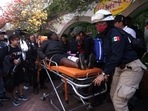Paramedics assist a woman after two subway trains collide head-on at a subway station, in Mexico City.