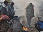 People warm themselves around a bonfire on a cold winter morning at Ghazipur market in New Delhi.