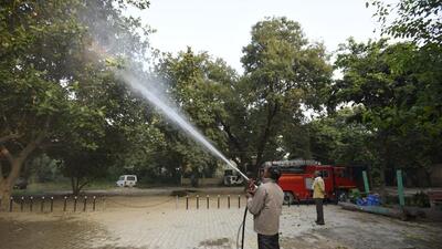 Gurugram, India - November 09: A firefighter sprinkles water on trees in a bid to curb air pollution, at Vikas Sadana near Mini Secretariat, in Gurugram, India, on Wednesday, November 9, 2022. (Photo by Parveen Kumar/Hindustan Times)
