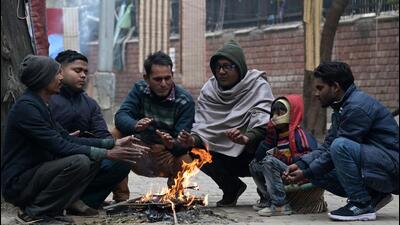 People sitting around a bonfire to protect themselves from cold in Chandigarh on Saturday. (Ravi Kumar/HT)