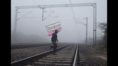 A cotton candy vendor crosses the railway track amid dense fog on a cold winter morning, in Prayagraj on Sunday. (ANI Photo) A cotton candy vendor crosses the railway track amid dense fog on a cold winter morning, in Prayagraj on Sunday. (ANI Photo)