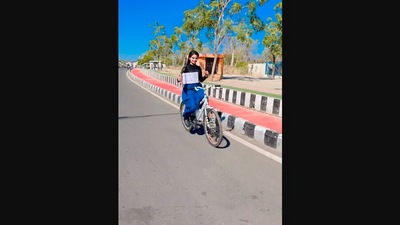 The image shows the woman riding a bicycle while holding a jumping rope. (Instagram/@iamsecretgirl023)