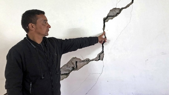 A resident shows a crack on the wall of his house at Joshimath in Chamoli district of Uttarakhand. (AFP)