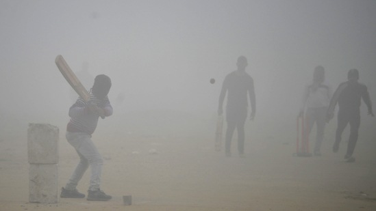 Gurugram: Youngsters play cricket amid low visibility due to a thick layer of fog on a cold winter morning, in Gurugram, Sunday, Jan. 8, 2023. (PTI)