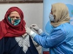A healthcare worker administers a booster dose to a woman in Srinagar. (PTI) A healthcare worker administers a booster dose to a woman in Srinagar. (PTI)