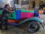 Jaipur: A worker gives final touches to antique car made of scraps and waste material before participating in an Auto Expo at a workshop, in Jaipur, Sunday, Jan 8, 2023. (PTI Photo) 