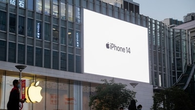 People walk near a display advertising the Apple iPhone 14 outside its store, following the coronavirus disease (COVID-19) outbreak in Shanghai, China, November 7, 2022. REUTERS/Aly Song