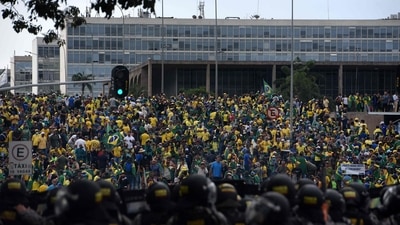 Supporters of Bolsonaro invading several governmental building are confronted by security forces (foreground). (AFP) Supporters of Bolsonaro invading several governmental building are confronted by security forces (foreground). (AFP)