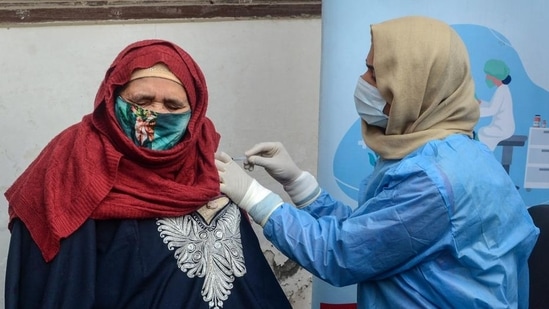 A healthcare worker administers a booster dose to a woman in Srinagar. (PTI)